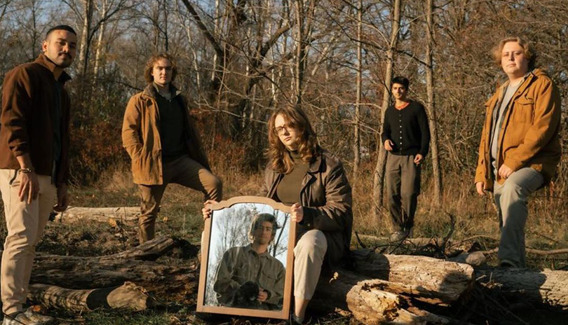 Group of musicians posing in a wooded area in London, Ontario