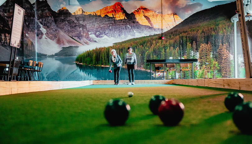 Two women playing a game of bocce ball at the vclubhouse in 100 Kellogg Lane