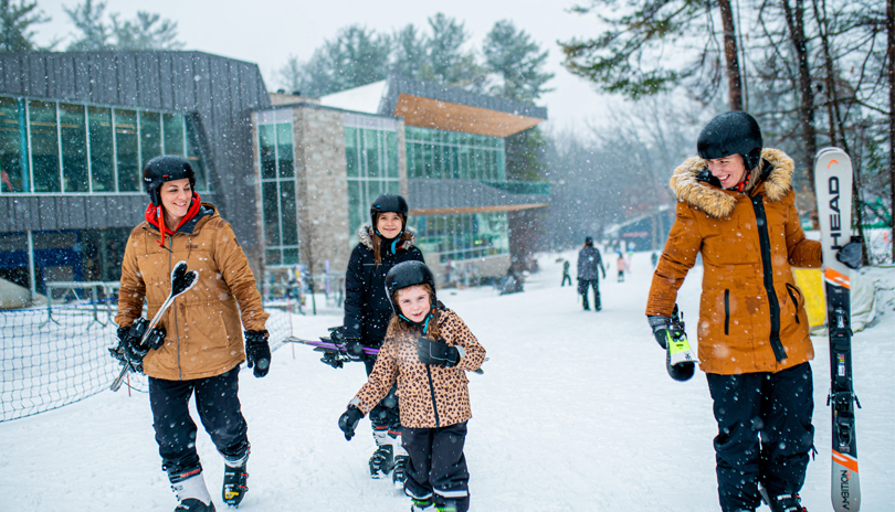 Family carrying ski equipment at Boler Mountain in London, ON