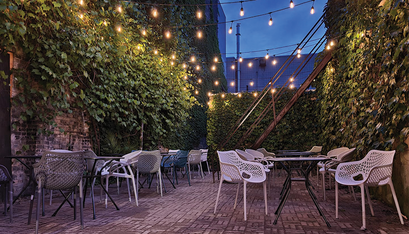 Che Restobar's patio at night lit up with lights