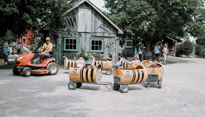 Tractor pulling buggies with children in them going for an adventure ride