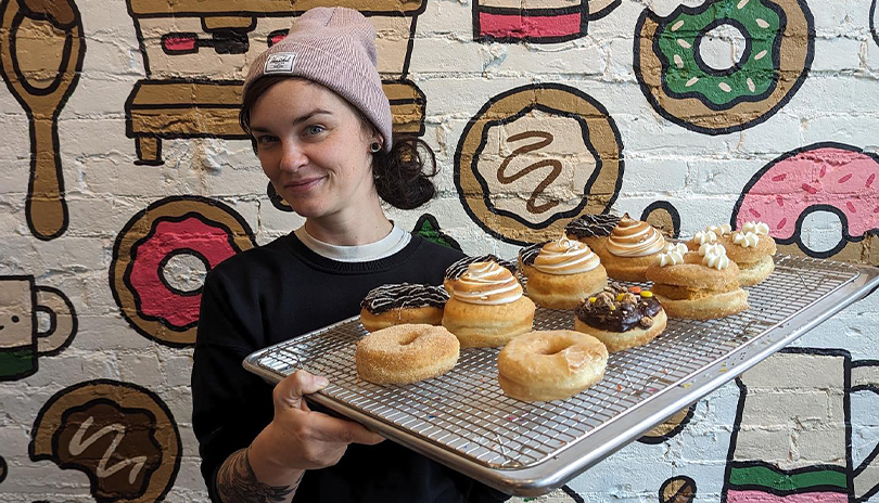 Woman holding a tray of fresh doughnuts from Dough EV in London, Ontario
