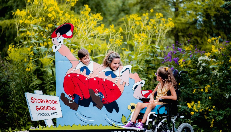 A family having fun at one of the character displays outdoors at Storybook Gardens located in London, Ontario