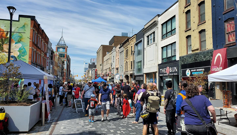 Crowd of people walking outside in the summer at Dundas PLace