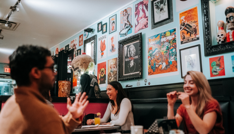 Various customers and dishes displayed on a table in The Early Bird located in London, Ontario