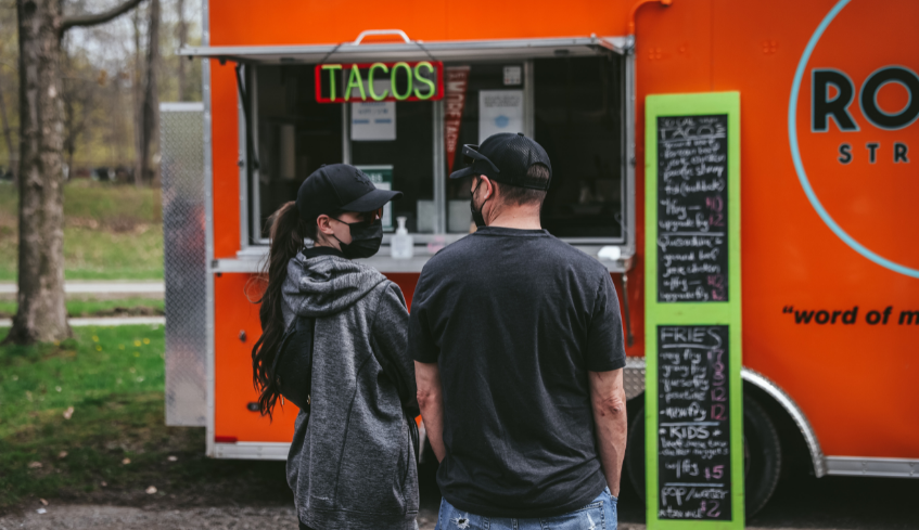 A couple standing in front of a taco food truck in London, Ontario