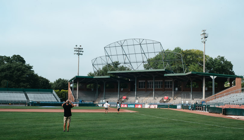 A group of people standing on the baseball field of Labatt Park, The World's Oldest Operating Baseball Grounds located in London, Ontario, Canada
