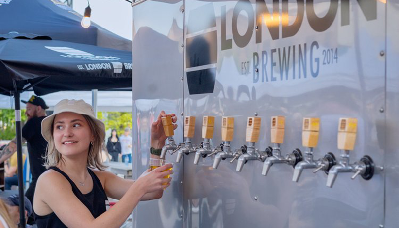Woman pouring a fresh beer from a selection of fresh beers from London Brewing