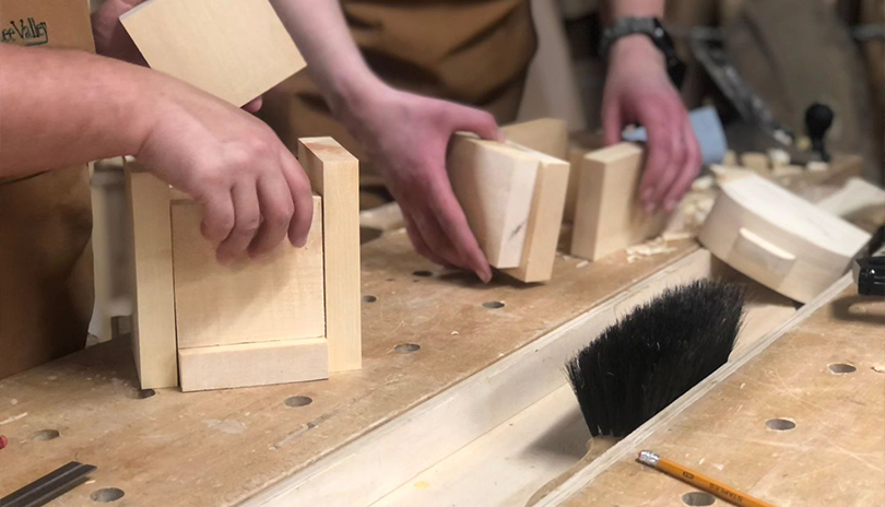 Busy hands sanding down wood blocks