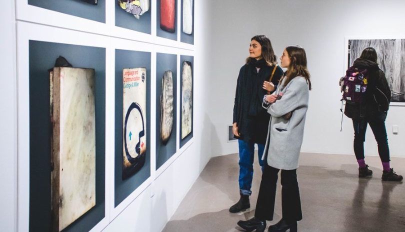 Individuals looking at art inside of Mcintosh Gallery