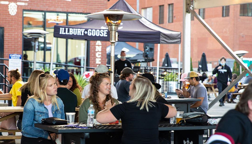 Outdoor patio at Powerhouse Brewery filled with people enjoying food and drink