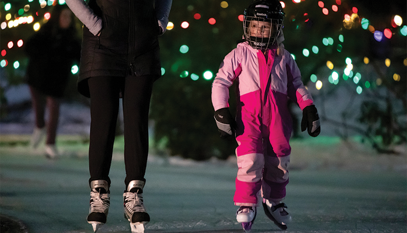 Parent and child skating on the ice at Storybook Gardens