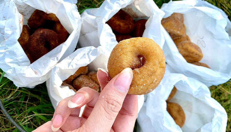 Woman holding a mini donut from The Donut Diva food truck