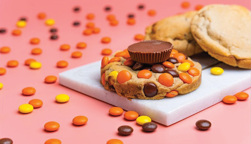 Reese's Peanut Butter cookie on a white marble tray with two other cookies behind it