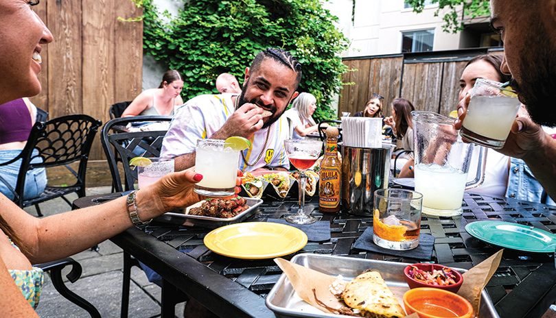 Group of friends eating and drinking on The Mule's patio in London, Ontario