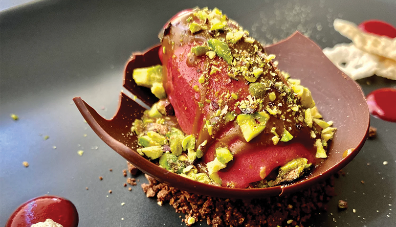 sorbet in a chocolate cup with pistachios and drizzle 