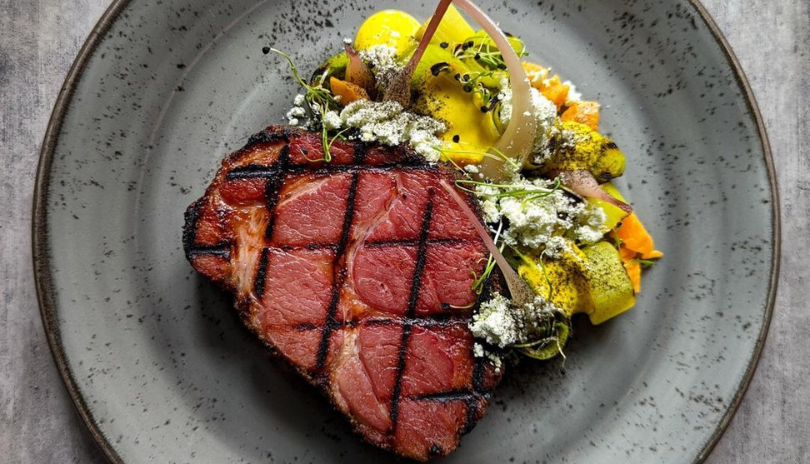 Steak with a side of seasonal veggies displayed at Wolfe Pack Company Bar in Wortley Village London Ontario