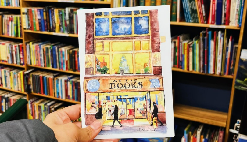 Postcard with a painting of Attic Books in front of a bookshelf