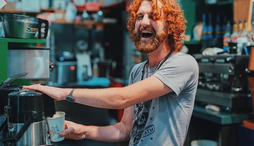 Barista laughing while brewing fresh coffee at Hasbeans in London, Ontario