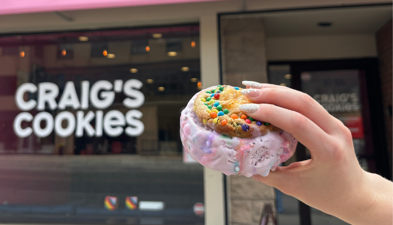 Hand holds a cookie sandwich up outside of Craig's Cookies in Downtown London.