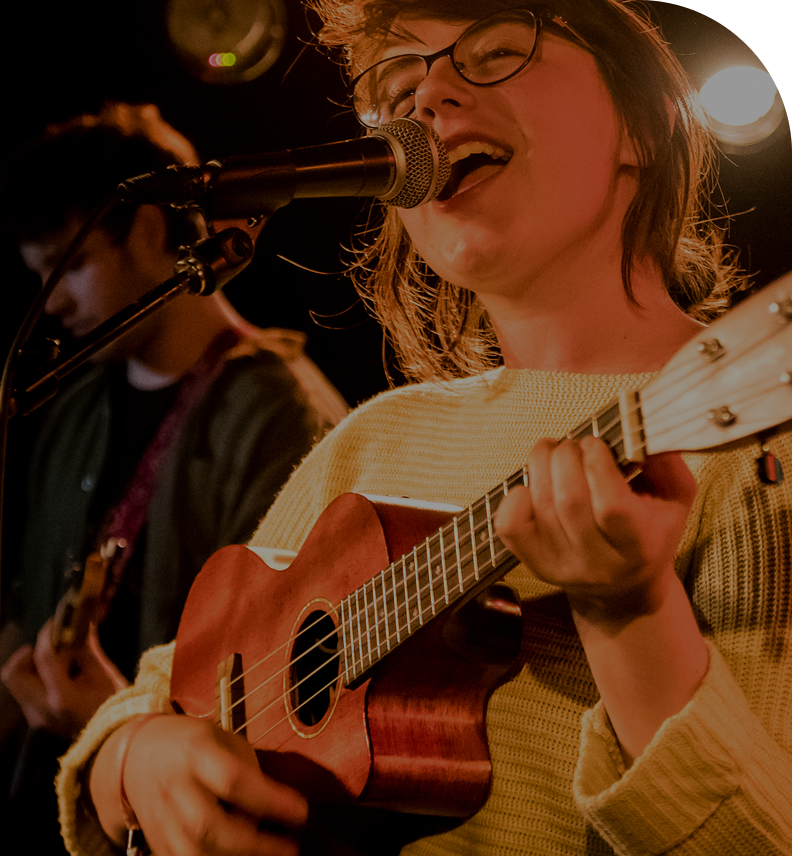 singer at microphone playing guitar