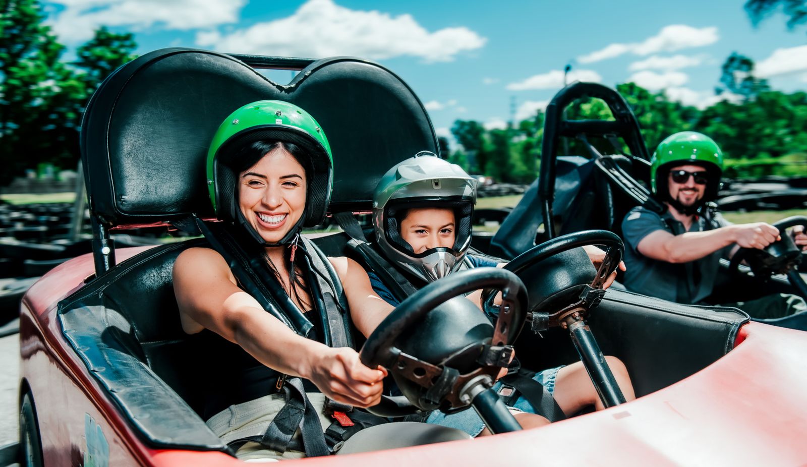 three peole driving a go kart at East Park