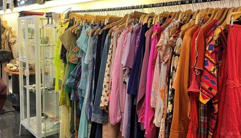 A rack packed with a rainbow assortment of vintage clothes.