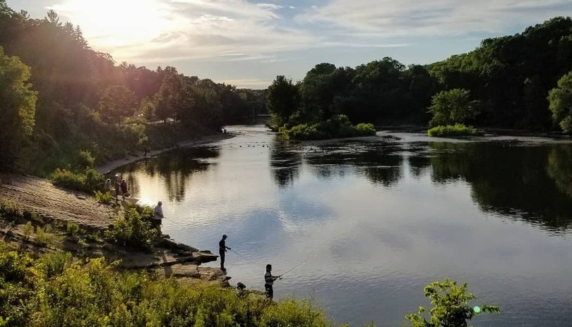 a group of people fishing at the Thames River off the The Thames Valley Parkway located in London, Ontario