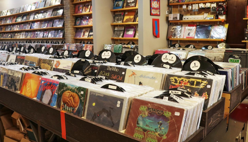 A table filled with records in a cozy record store.