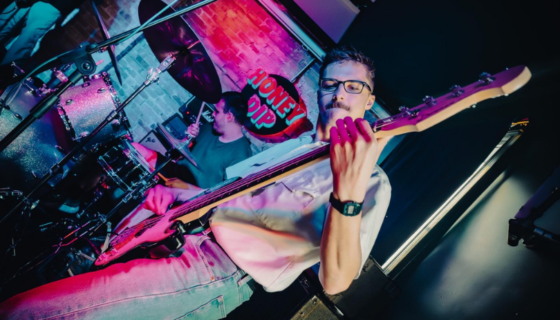 A man plays a guitar in small concert venue Honey Dip in London, Ontario.