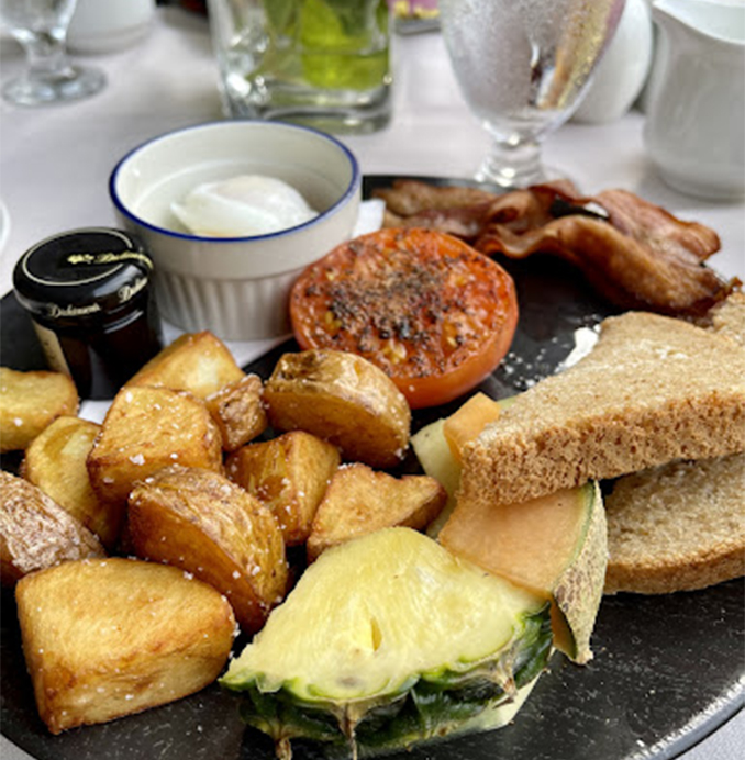 breakfast entree with potatoes, bacon, fruit and toast 