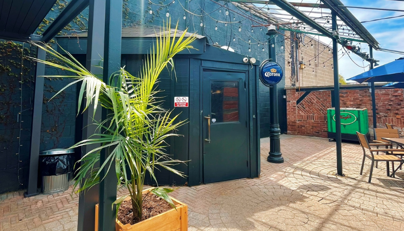 Sunny patio at Joe Kool's with plants and patio furniture.