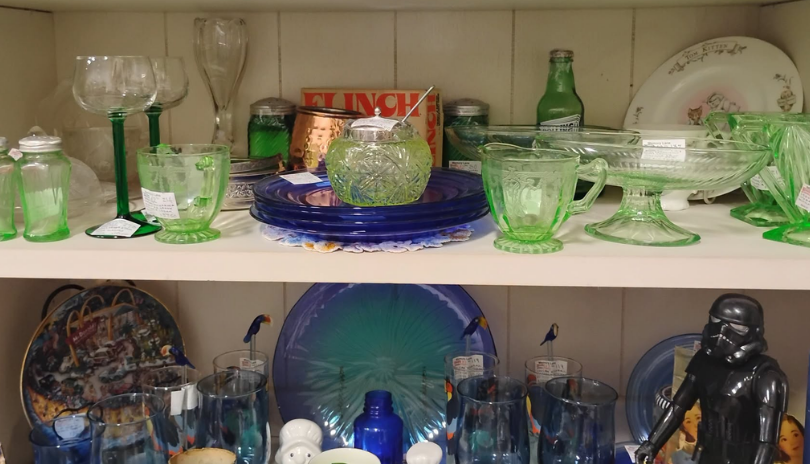 A display of antique dishes with one shelf of green and one of blue dishes at Memory Lane Antiques in London, Ontario.