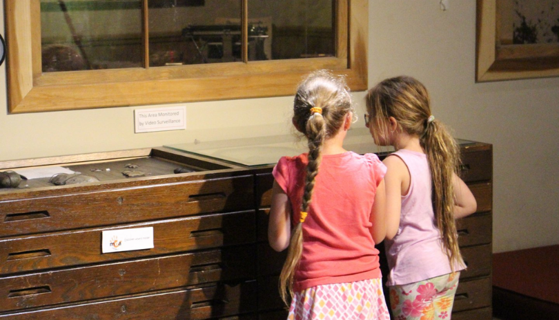 Two children look at artifacts at Museum of Ontario Archaeology