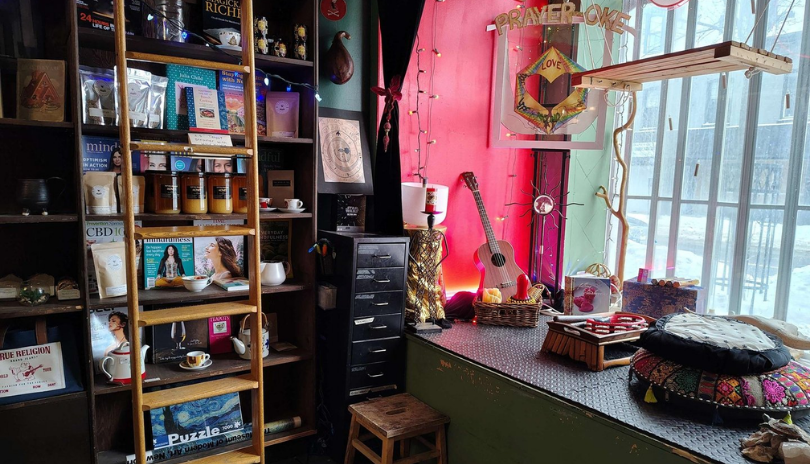 A shelf of books about mysticism in a shop filled with other occult items.