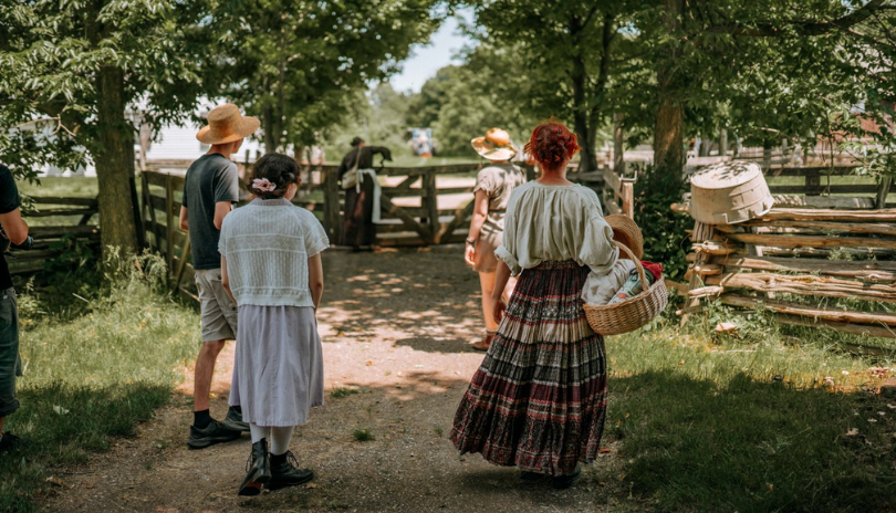 Group of people walk on a path at Fanshawe Pioneer Village.