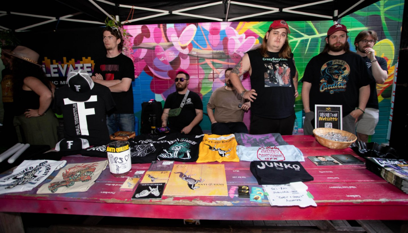 Artists at a merch table at Punk Rock Flea Market in London, Ontario.