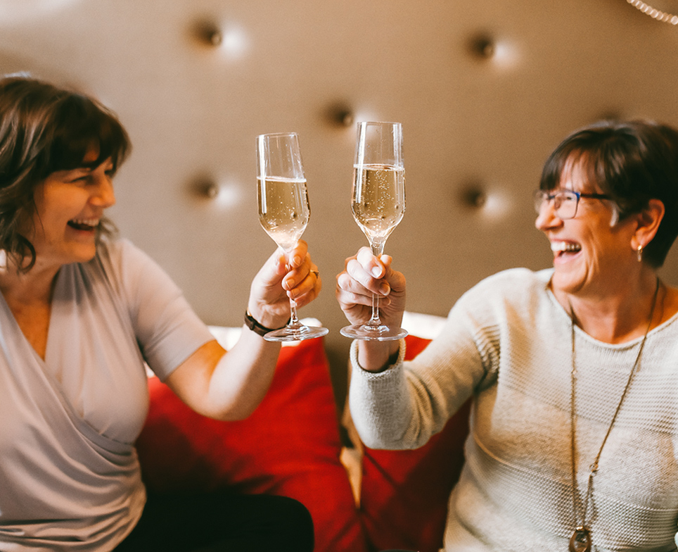 two people holding champagne glasses toasing