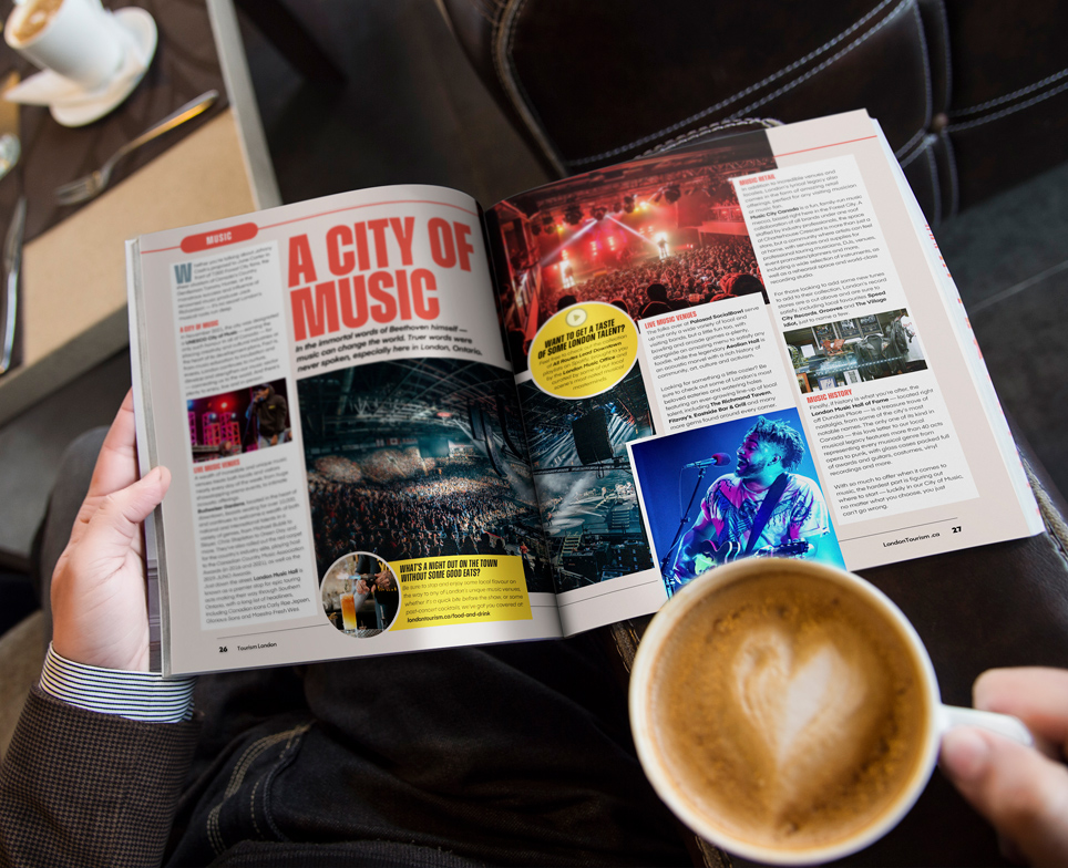 person reading the london visitor guide holding a coffee cup