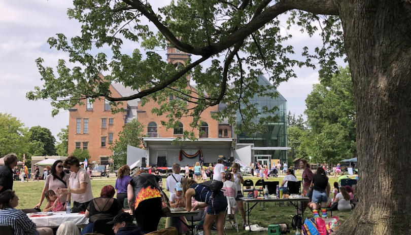 A crowd of people enjoy activities on The Green during Wortley Pride Festival.