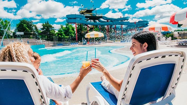 Two woman lounging near the wave pool on a sunny day at East Park locate din London, Ontario