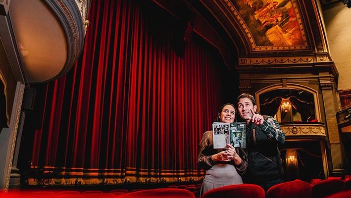 A couple looking at the main stage inside of the Grand Theatre located in London, Ontario