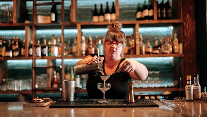 A female bartender preparing a mixed drink at Hunter & Co. located in London, Ontario