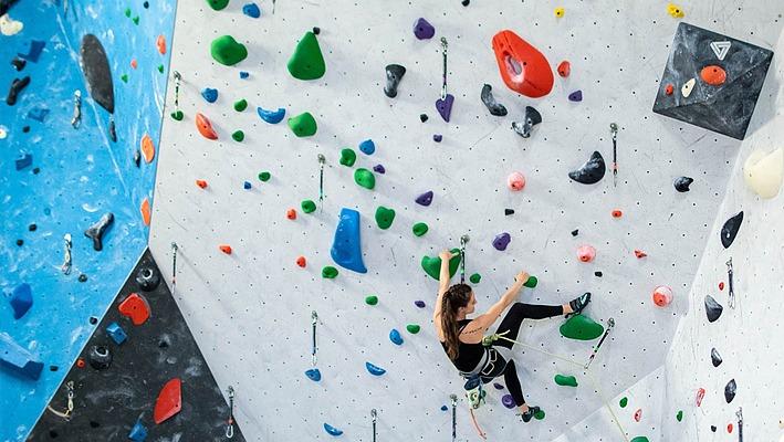 A person climbing a large wall at the Junction Climbing Centre located in London, Ontario.
