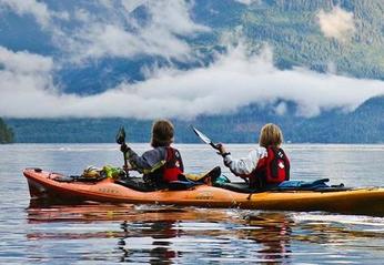 Two paddlers outdoors on a lake in their Nova Craft Canoe