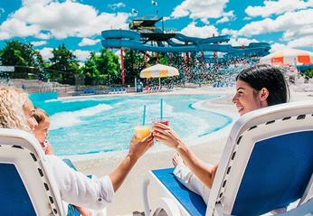 Two woman lounging near the wave pool on a sunny day at East Park locate din London, Ontario