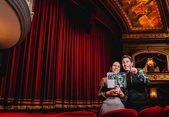 A couple looking at the main stage inside of the Grand Theatre located in London, Ontario