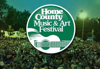 Home County Music & Art Festival logo over a large crowd outdoors attending the festival in London, Ontario