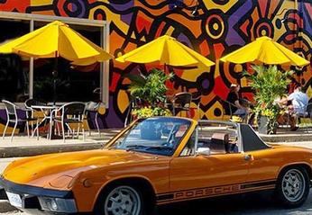 An orange Porsche convertible car located outside of Locomotive Espresso South in London, Ontario