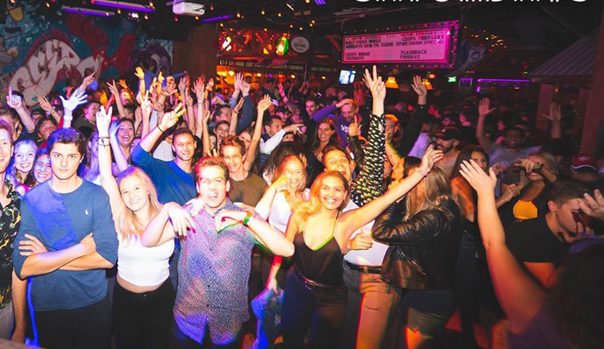 Large groups of people dancing and cheering inside The Ceeps’s / Barney’s main room located in London, Ontario 